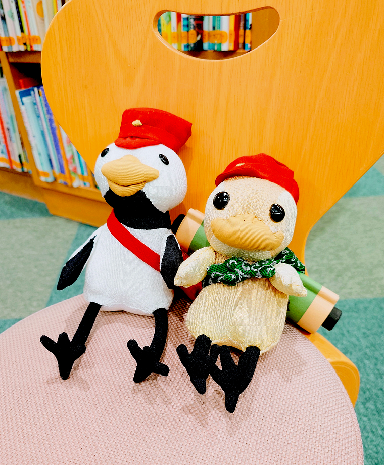 つるさんとみたらしのぬいぐるみ。小さな児童用の椅子に腰かけている。